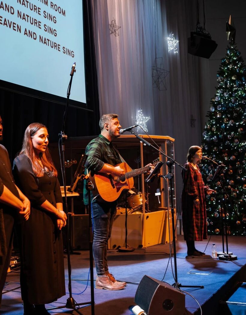 The worship band leading carols beside the Christmas tree at Hope Church