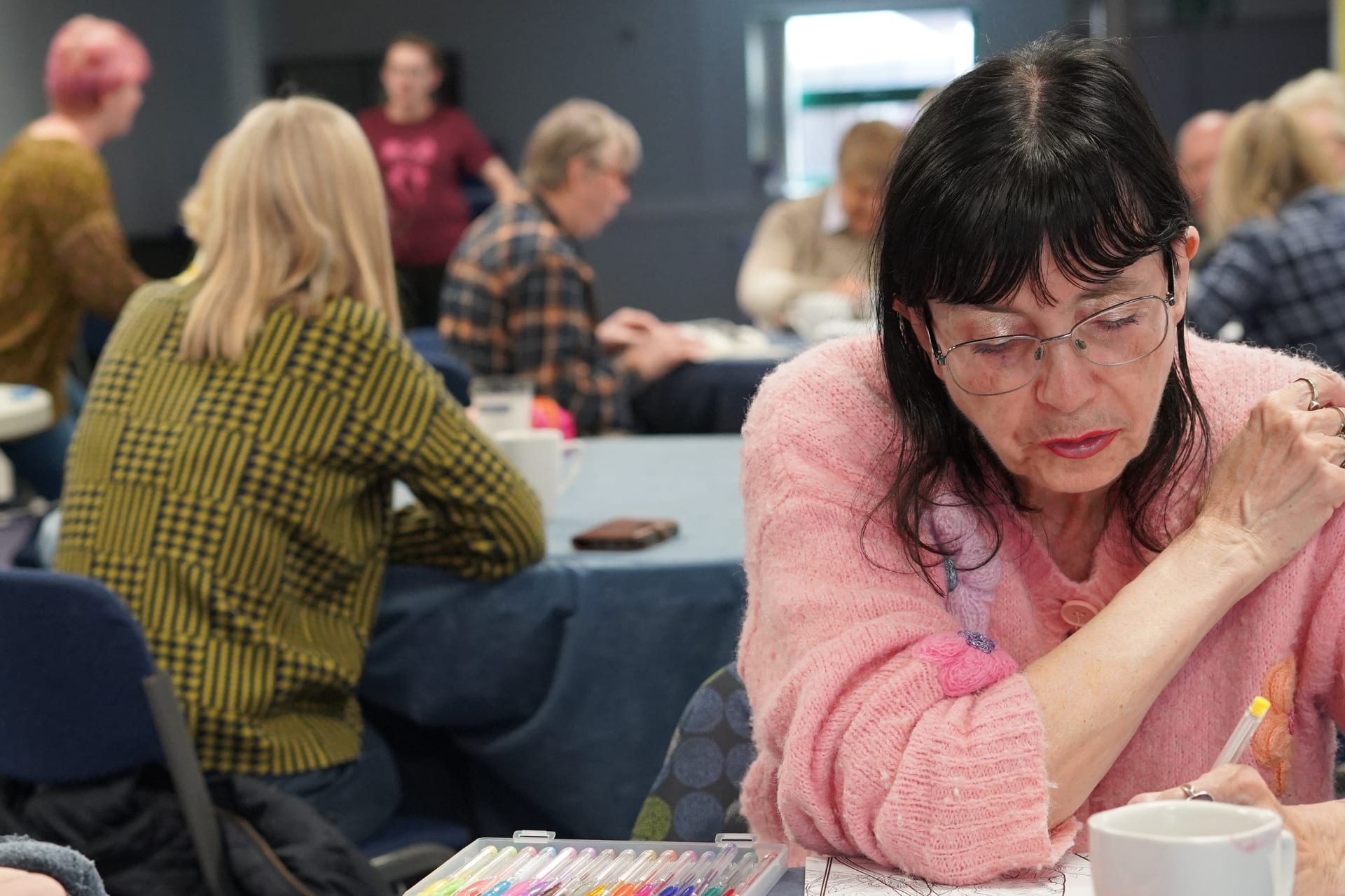 A woman colouring at the Pick and Mix daytime group