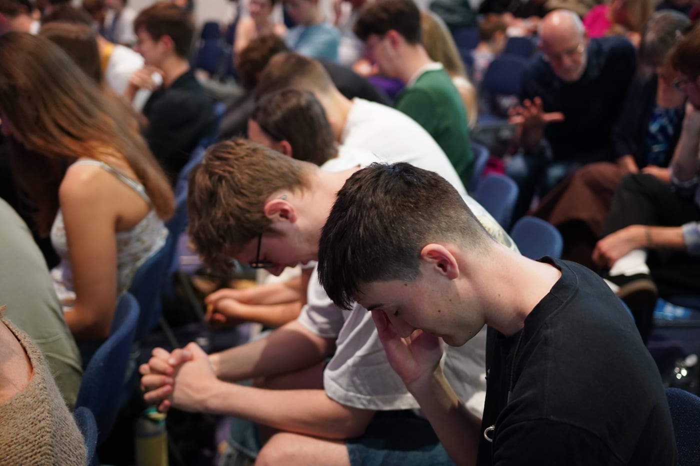 Church members praying together with heads bowed