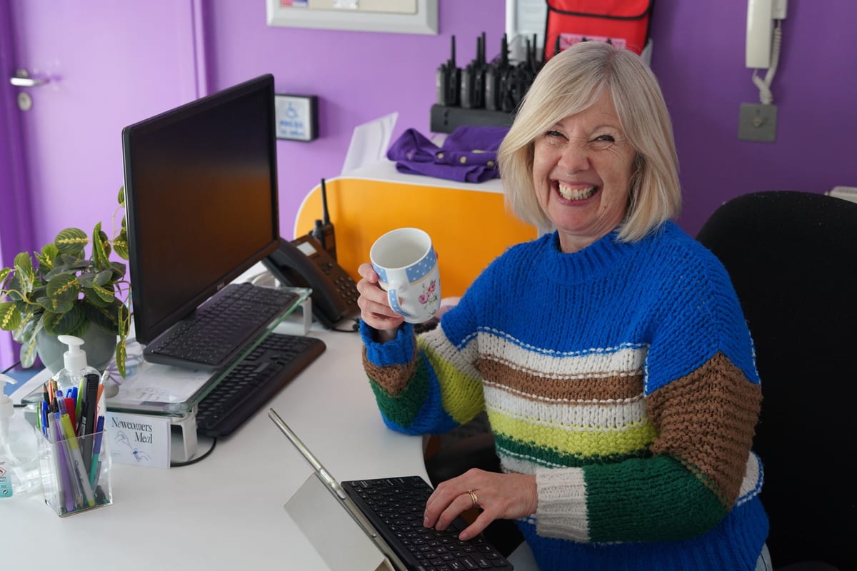 A Hope volunteer welcoming people at reception