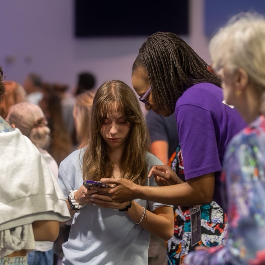 A welcome team member helping someone connect to live translation on their phone